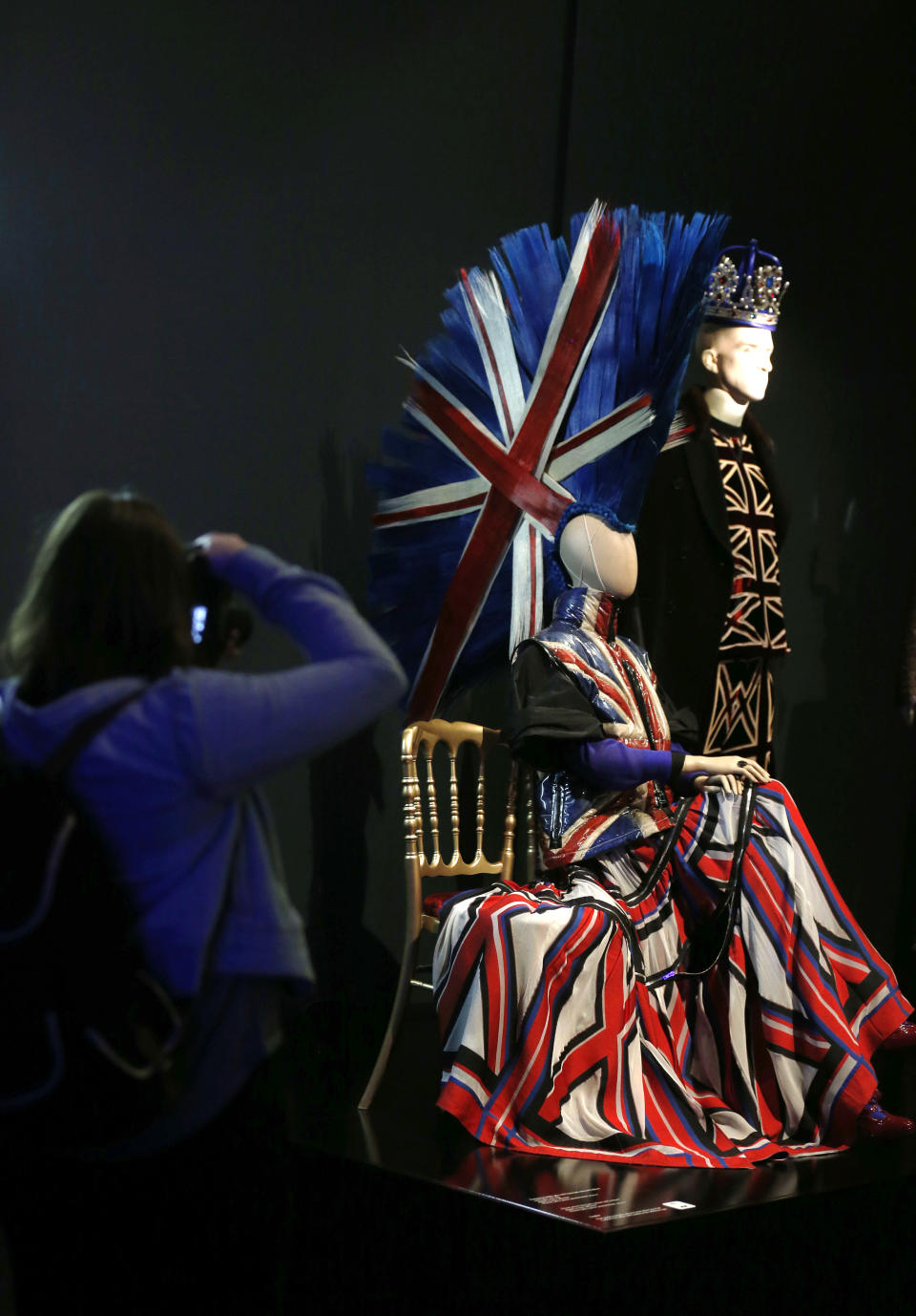 A visitor takes picture of a creation of French couturier Jean Paul Gaultier during the launch of his exhibition 'The Fashion World of Jean Paul Gaultier : From the Sidewalk to the Catwalk' at the Barbican Art Gallery in London, Tuesday, April 8, 2014. (AP Photo/Sang Tan)