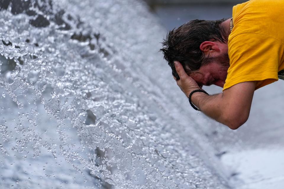 A man cools off at a fountain during a sunny day in Belgrade, Serbia (AP)