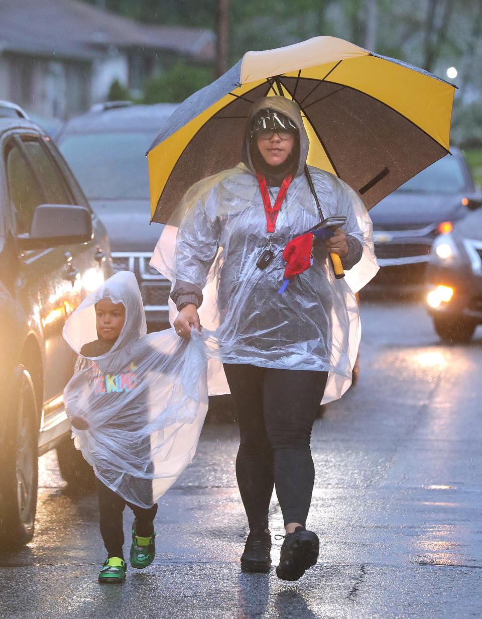 Jayland Walker protesters march along Fess Avenue in the rain Friday in Akron.