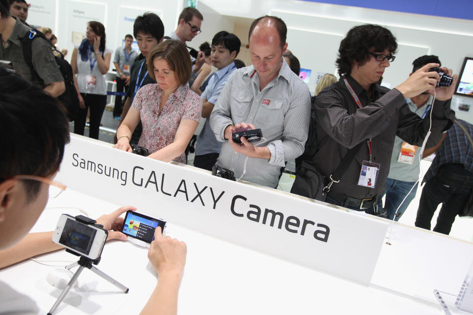 BERLIN, GERMANY - AUGUST 30: Visitors try out the new Samsung Galaxy Camera, which combines a smartphone and a digital camera with a zoom lens, during a press day at the Samsung stand at the IFA 2012 consumer electronics trade fair on August 30, 2012 in Berlin, Germany. IFA 2012 will be open to the public from August 31 through September 5. (Photo by Sean Gallup/Getty Images)