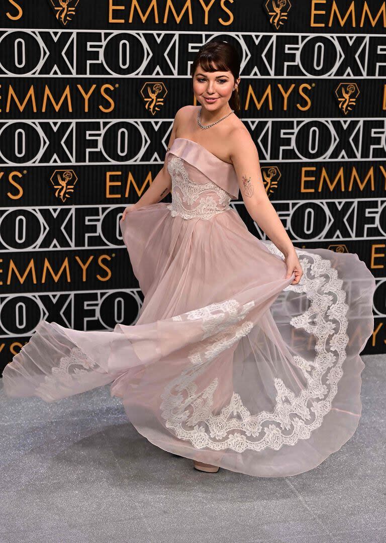 La actriz Sammi Hanratty muestra divertida su romántico diseño en rosa con escote palabra de honor de tul y encaje de Dolce & Gabbana
