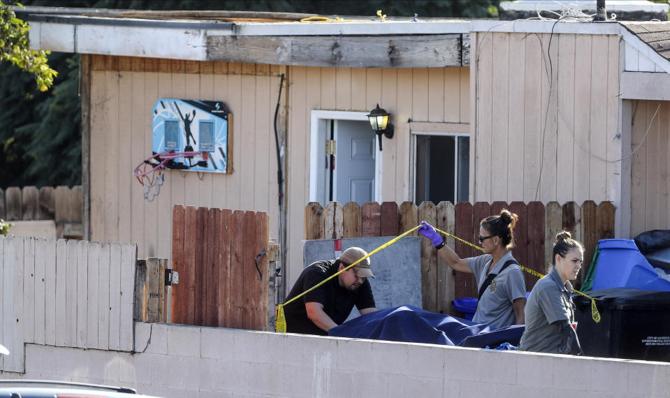 A body is carried out on a gurney at the home where two adults and three children died from gunshot wounds during a domestic shooting in the Paradise Hills area in San Diego, Calif., Saturday, Nov. 16, 2019. A husband and wife and three of their young children died Saturday morning at the family's San Diego home in what police believe was a murder-suicide sparked by a bitter divorce. One son is in critical condition. (Hayne Palmour IV/The San Diego Union-Tribune via AP)