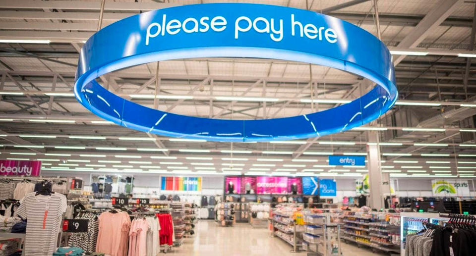 A blue ring attached to the ceiling inside a Kmart store indicating where to pay.