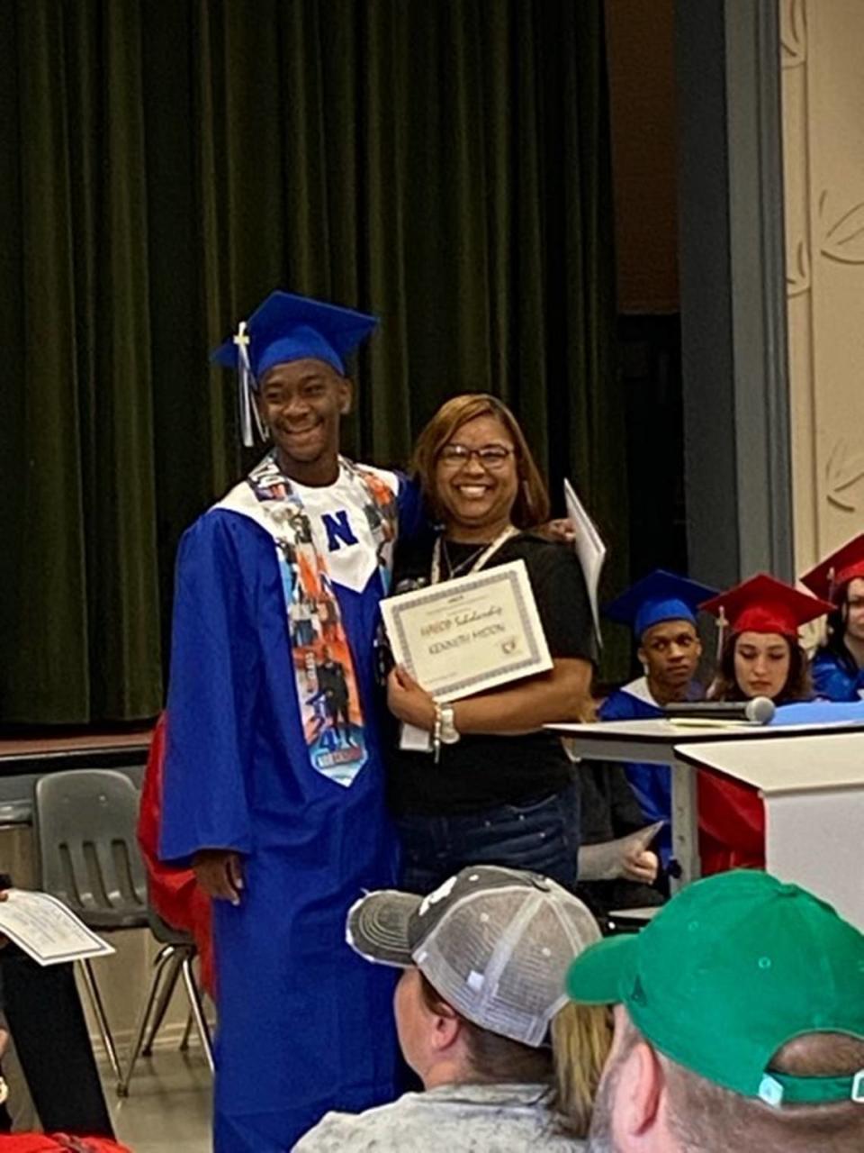 Northside High School student athlete Kenneth Milton Jr. accepts his $1,000 scholarship at Winn Academy on May 16. He said the stipend will help further his education at Georgia State University.