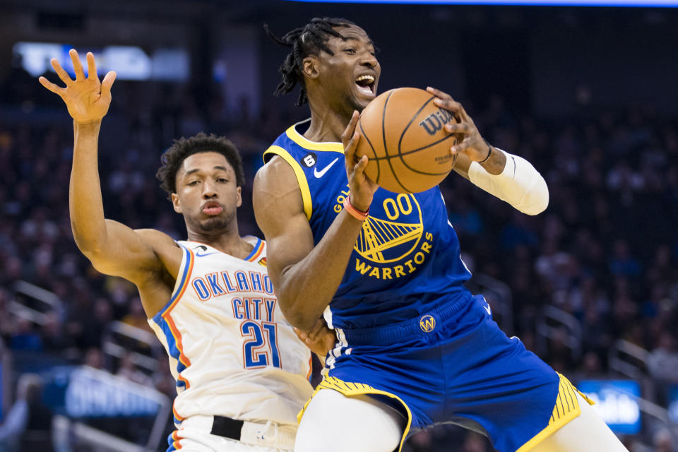 Golden State Warriors forward Jonathan Kuminga (00) passes in front of Oklahoma City Thunder forward Aaron Wiggins (21) during the first half of an NBA basketball game in San Francisco, Monday, Feb. 6, 2023. (AP Photo/John Hefti)