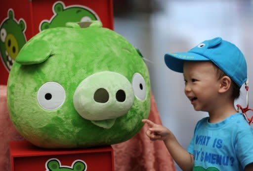 A child touches a "Bad Piggies" stuffed toy from the "Angry Birds" game during a news conference in Taipei on September 27. "Angry Birds" maker Rovio launched a new title allowing users to play as the "Bad Piggies" from the smash-hit game, and take revenge on the birds who attacked them with slingshots