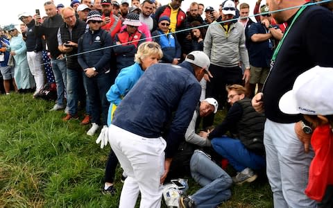 US golfer Brooks Koepka reacts next to the injured spectator - Credit: FRANCK FIFE/AFP