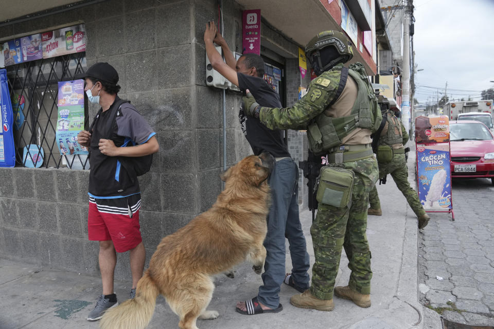 Soldados detienen y registran a un peatón en busca de armas y su perro salta sobre él, mientras patrullan zonas residenciales en el norte de Quito, Ecuador, el jueves 11 de enero de 2024. El presidente Daniel Noboa decretó el lunes el estado de emergencia nacional debido a una ola de criminalidad, una medida que permite a las autoridades suspender los derechos de las personas y movilizar a los militares. El gobierno también impuso un toque de queda. (Foto AP/Dolores Ochoa)