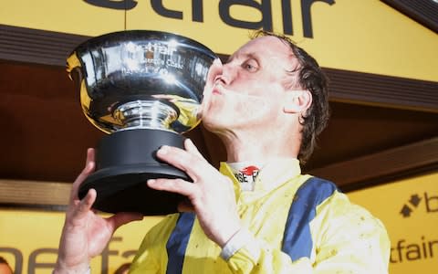 Robbie Power poses with the trophy after winning the Betfair Steeple Chase on Lostintranslation - Credit: PA