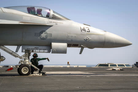 FILE PHOTO: A flight deck crew ensures an F/A-18E Super Hornet is seated in the catapult shuttle on the flight deck of the aircraft carrier USS Abraham Lincoln (CVN 72), in Arabian Sea, May 23, 2019. Jeff Sherman/U.S. Navy/Handout via REUTERS