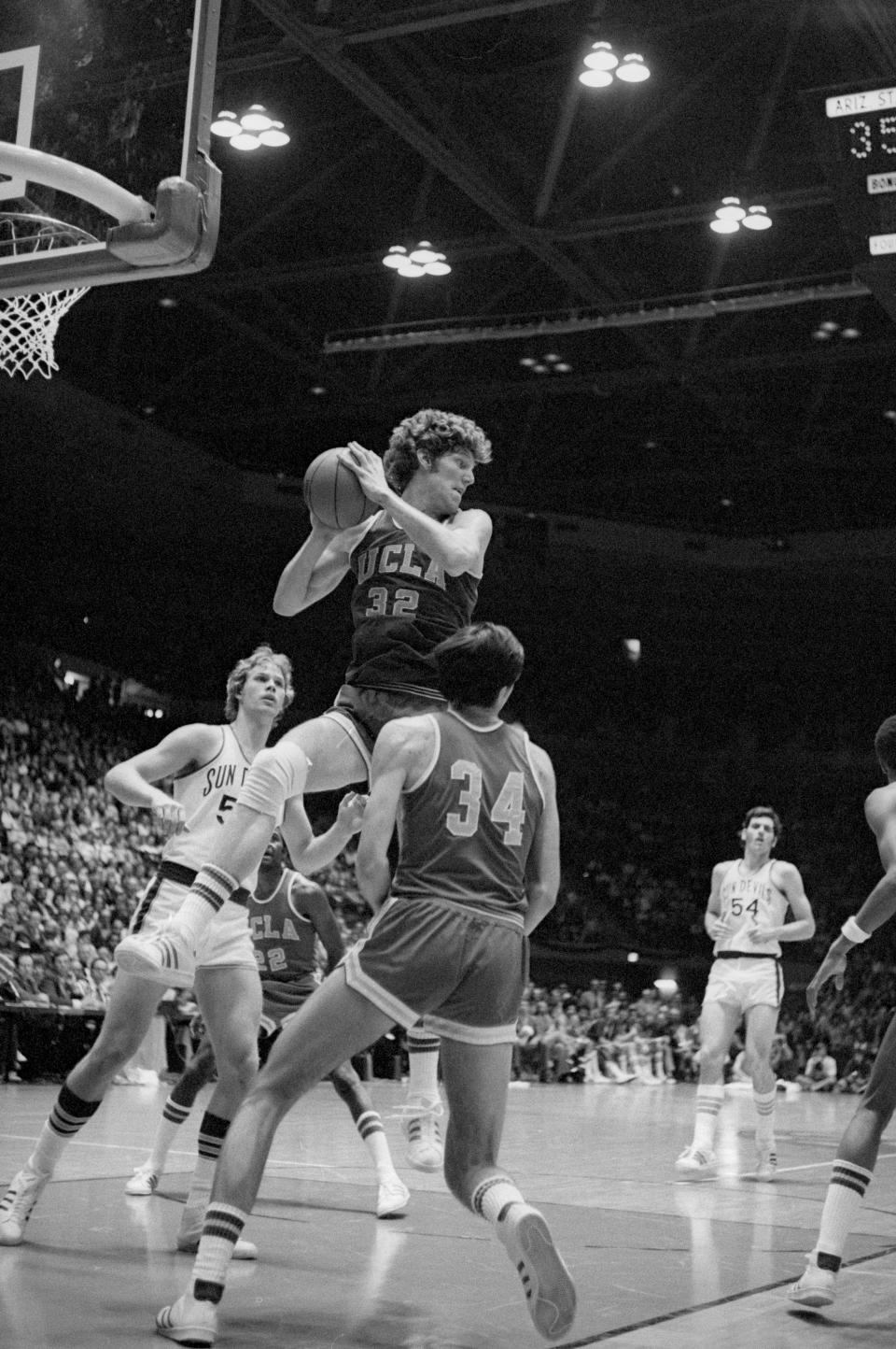 Original Caption: Westwood, Calif.: Red-haired Bill Walton, the reigning king of college basketball, goes high into the air to bring down a rebound during play against Arizona State. No. 1 ranked UCLA won the game 98-81 as Walton scored 26 points.