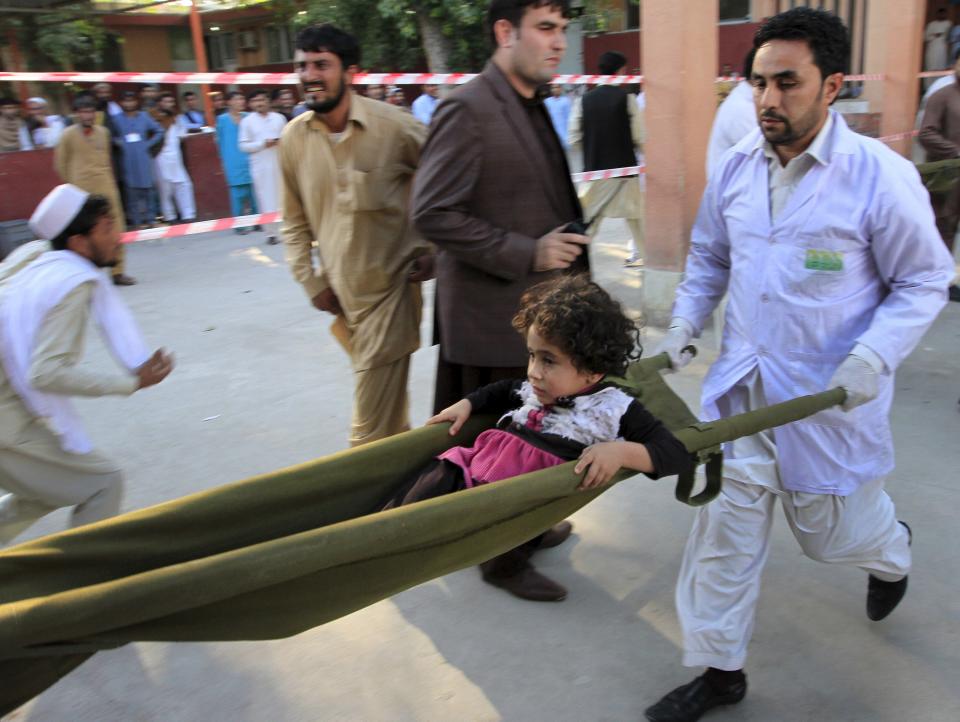 Rescue workers carry a girl who was injured after an earthquake in Jalalabad