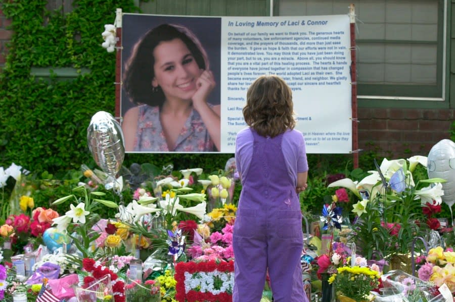 In this April 21, 2003, file photo, a person stands in front of a memorial in honor of Laci Peterson outside the house Laci shared with her husband in Modesto. (AP Photo/Marcio Jose Sanchez, File)