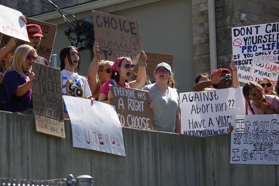 Protesters chant behind the Women's Care Center on June 27. They alleged the center misleads pregnant people with dangerous information to coerce them out of having an abortion.