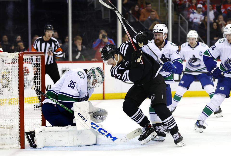 Vancouver Canucks goaltender Thatcher Demko (35) makes a save against New Jersey Devils left wing Jesper Bratt (63) during the second period of an NHL hockey game, Saturday, Jan. 6, 2024, in Newark, N.J. (AP Photo/Noah K. Murray)