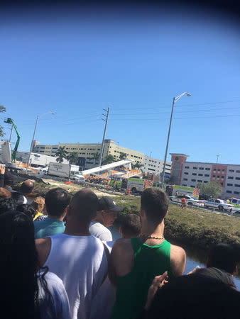 People view the scene of a collapsed pedestrian bridge at Florida International University in Miami, Florida, U.S., March 15, 2018 in this image obtained from social media. Instagram/ @barbituriinsua via REUTERS