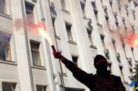 A protester lights a flare during a rally against the law to provide separatist-held regions with a special status near the Ukrainian parliament in Kiev, September 17, 2014. REUTERS/Valentyn Ogirenko