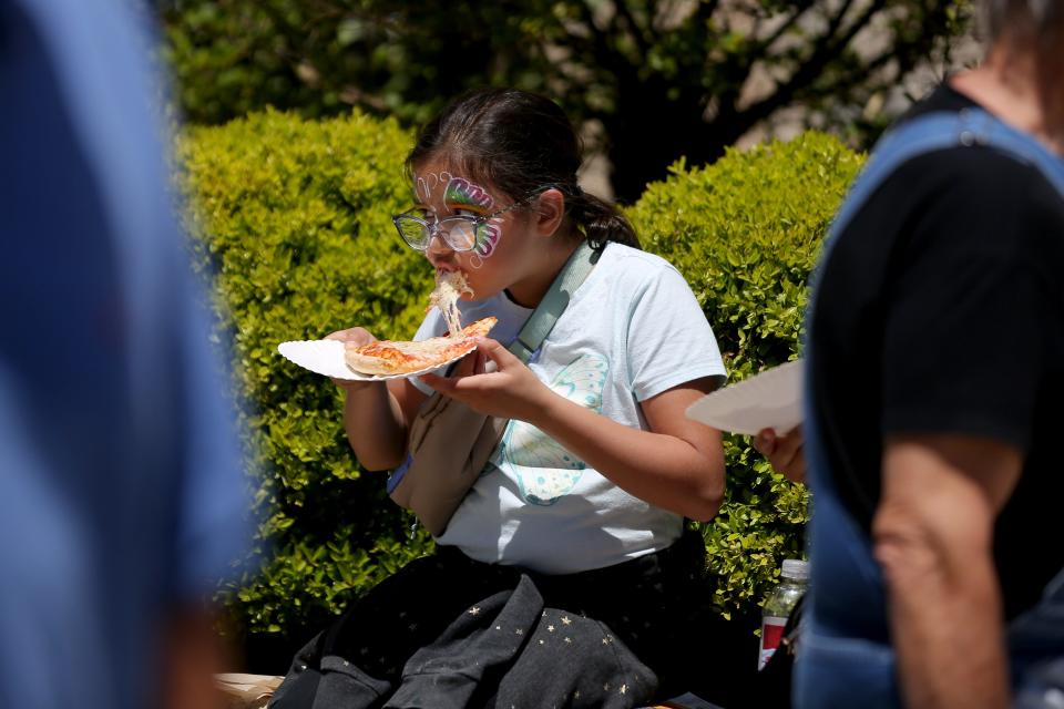 Natalie Acosta, 7, eats a slice of pizza April 29, 2023, during the Festival of the Arts.