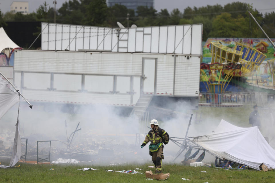 A firefighter at the Eritrean cultural festival "Eritrea Scandinavia" in Stockholm Thursday, Aug. 3, 2023. A violent clash at an Eritrea-themed culture festival in Sweden has caused a chaos as about a thousand anti-Eritrean government protesters stormed the outdoor festival venue throwing stones, setting fire on booths and tearing down tents. (Magnus Lejhall/TT News Agency via AP)