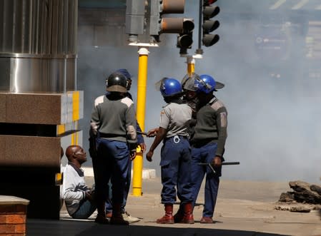 Riot police detain a man during clashes after police banned planned protests over austerity and rising living costs called by the opposition Movement for Democratic Change (MDC) party in Harare