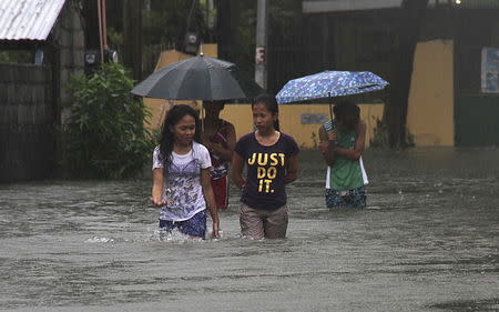 Residents wade across floodwaters caused by Typhoon Goni in Bacnotan, La Union, in northern Philippines August 22, 2015. REUTERS/TJ Corpuz