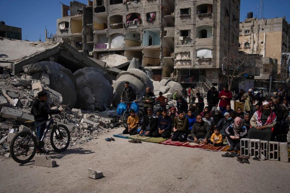 Palestinians pray in front of a mosque destroyed by the Israeli airstrikes in Rafah, Gaza Strip, Friday, March 8, 2024, ahead of the holy Islamic month of Ramadan.