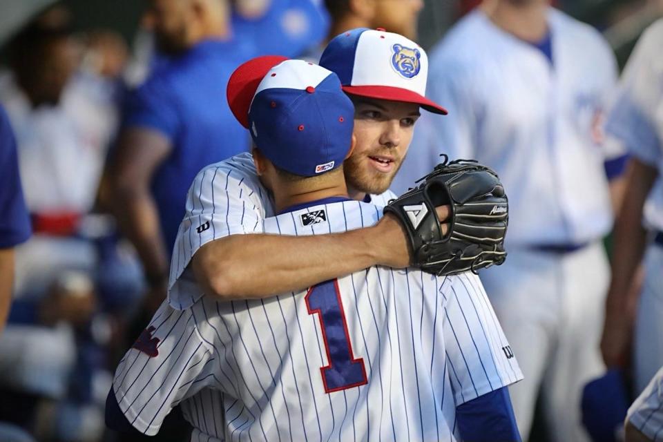 Iowa Cubs pitcher Brandon Hughes hugs outfielder Zach Davis following the end of an inning. Davis made a diving catch to get Hughes out of a jam.