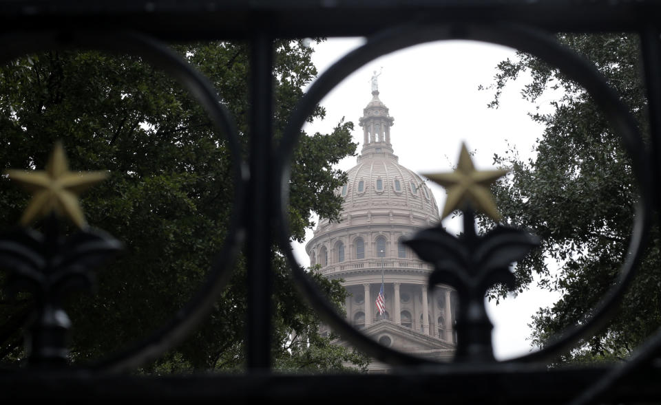 FILE - This Dec. 9, 2013 file photo shows theTexas Capitol through the south gate in Austin, Texas. The Texas Capitol in Austin opened in 1885, built from pink granite quarried in Texas Hill Country. The interior is filled with famous paintings and statues and the grounds are home to statues, a visitor center and the governor's mansion. It's one of a number of free things to see and do in Austin. (AP Photo/Eric Gay, File)