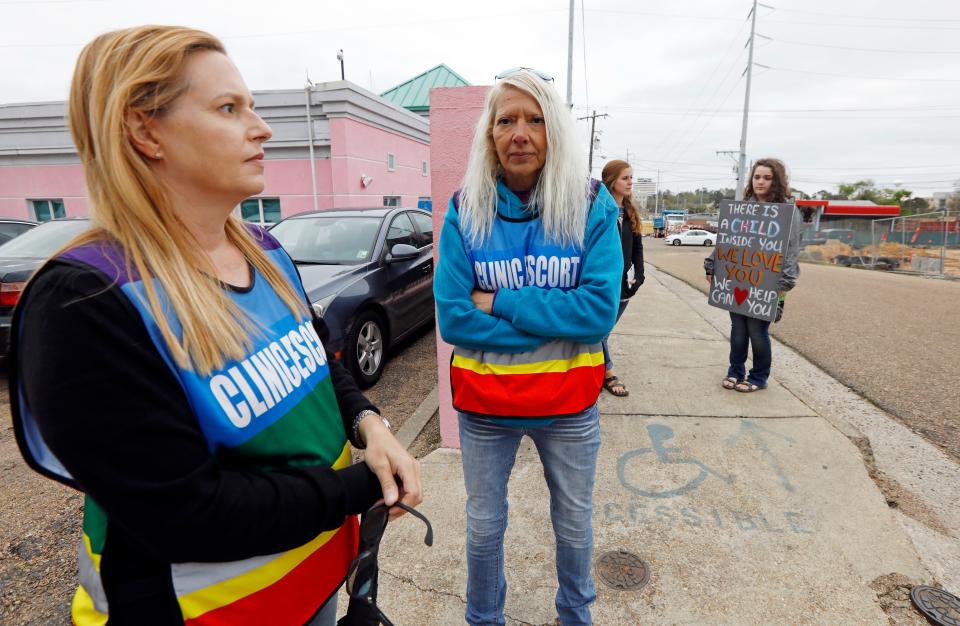 Clinic escorts Kim Gibson, left, and Derenda Hancock, second from left, and anti-abortion sidewalk counselors Beka Tate, second from right, and a woman who only gave her first name, Lauren, stand outside the Jackson Women's Health Organization's clinic on March 20, 2018.
