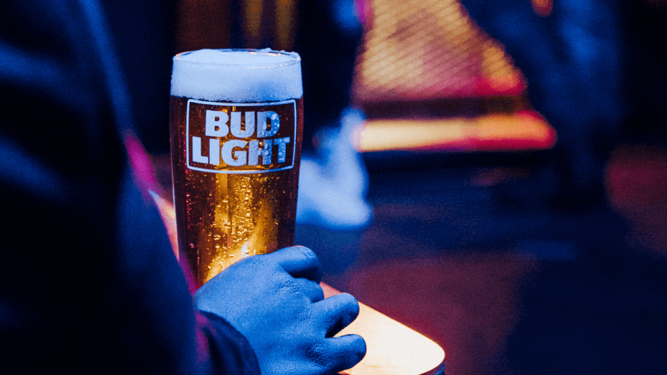 Hand holding glass of Bud Light beer