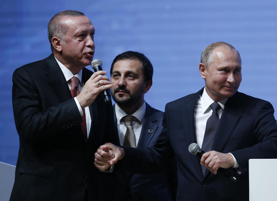 Turkey's President Recep Tayyip Erdogan, left, and Russian President Vladimir Putin, right, hold hands as they attend an event marking the completion of one of the phases of the Turkish Stream natural gas pipeline, in Istanbul, Monday, Nov. 19, 2018. The two 930-kilometer (578-mile) lines when finished are expected to carry 31.5 billion cubic meters (1.1 trillion cubic feet) of Russian natural gas annually to European markets, through Turkish territories. (AP Photo/Lefteris Pitarakis)