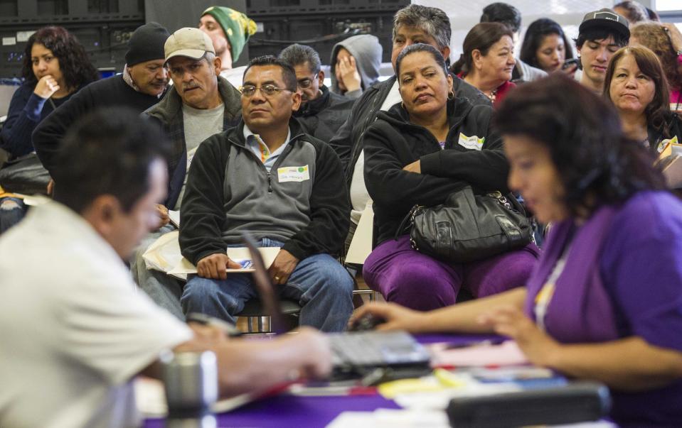 Applicants wait during a health care enrollment event at SEIU-UHW office, Monday, March 31, 2014, in Commerce, Calif. Monday marks this year's open enrollment deadline, but consumers will get extra time to finish their applications. (AP Photo/Ringo H.W. Chiu)
