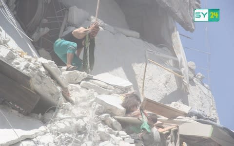 A father trying to rescue his children after an Russian or Syrian regime airstrike in Ariha, Idlib - Credit: Sy24