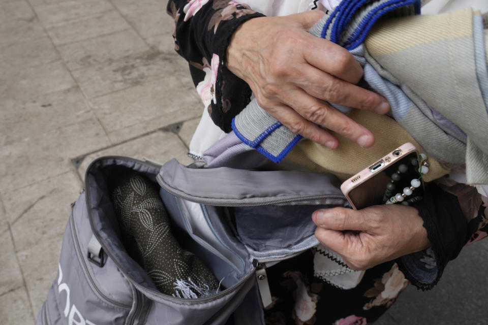 During the annual Hajj pilgrimage, Egyptian pilgrim Umaima displays the contents of her bag outside the Grand Mosque in Mecca, Saudi Arabia, Saturday, June 24, 2023. Straw hats, cross-body bags, and collapsible chairs are some essentials pilgrims have on them as they perform the Hajj. The fifth pillar of Islam is a profoundly spiritual experience but requires practical and specific preparation to deal with hours of walking in scorching temperatures, camping stints, and massive crowds. (AP Photo/Amr Nabil)