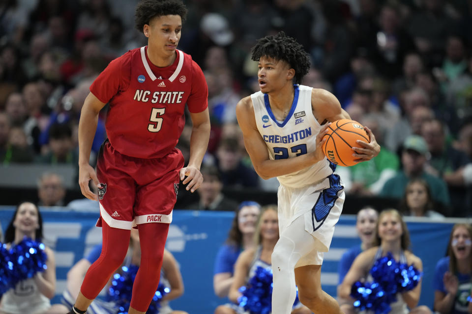 Creighton guard Trey Alexander, right, looks to pass the ball as North Carolina State guard Jack Clark defends in the first half of a first-round college basketball game in the men's NCAA Tournament Friday, March 17, 2023, in Denver. (AP Photo/John Leyba)