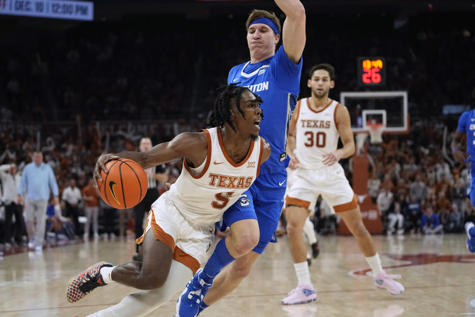 Texas guard Marcus Carr (5) drives around Creighton guard Baylor Scheierman during the second half of an NCAA college basketball game in Austin, Texas, Thursday, Dec. 1, 2022. (AP Photo/Eric Gay)