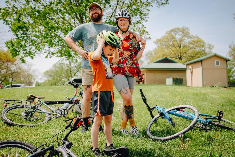 A child steadies his helmet as bikers listen to instructions during a bike ride event Sunday on Mother’s Day in Stephens Lake Park.