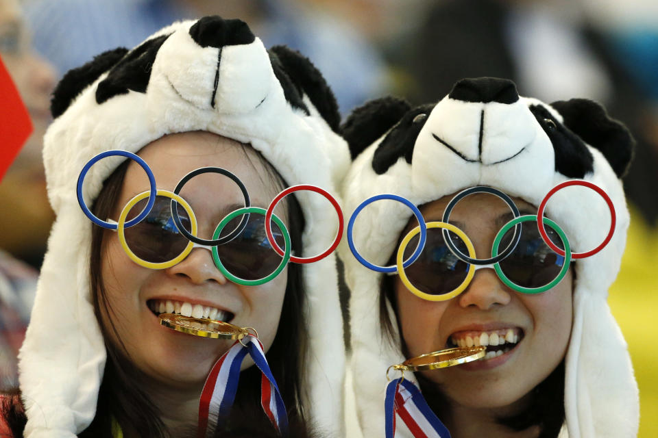 Two Chinese fans pause for photos prior to the Women's Synchronized 10 Meter Platform Diving final at the Aquatics Centre in the Olympic Park during the 2012 Summer Olympics, London, Tuesday, July 31, 2012. (AP Photo/Jae C. Hong)