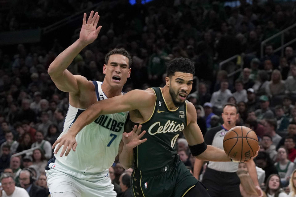 Boston Celtics forward Jayson Tatum (0) drives past Dallas Mavericks center Dwight Powell (7) during the first half of an NBA basketball game, Wednesday, Nov. 23, 2022, in Boston. (AP Photo/Mary Schwalm)