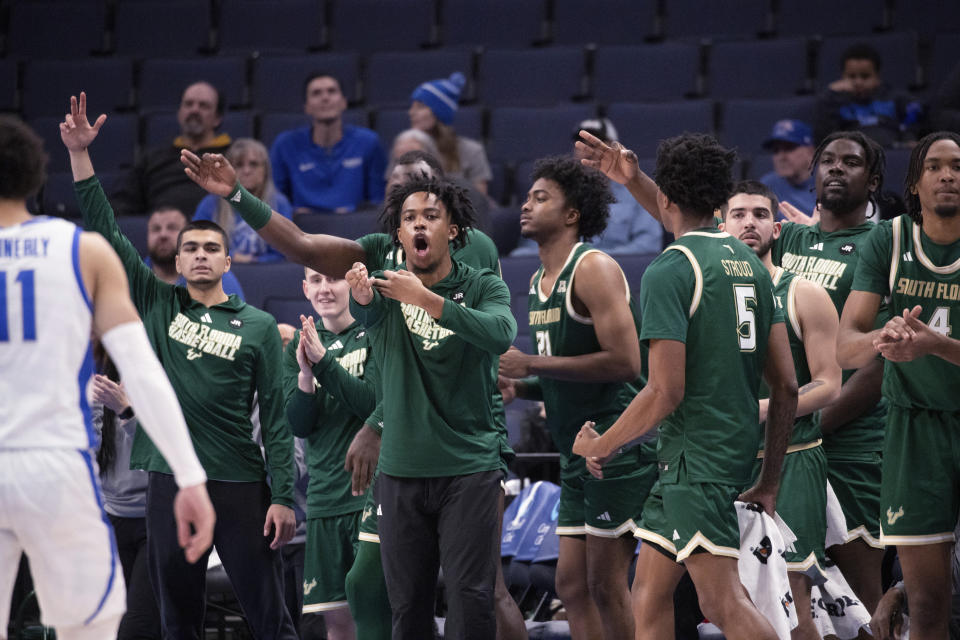 The South Florida bench celebrates a 3-point basket during the second half of the team's NCAA college basketball game against Memphis on Thursday, Jan. 18, 2024, in Memphis, Tenn. (AP Photo/Nikki Boertman)