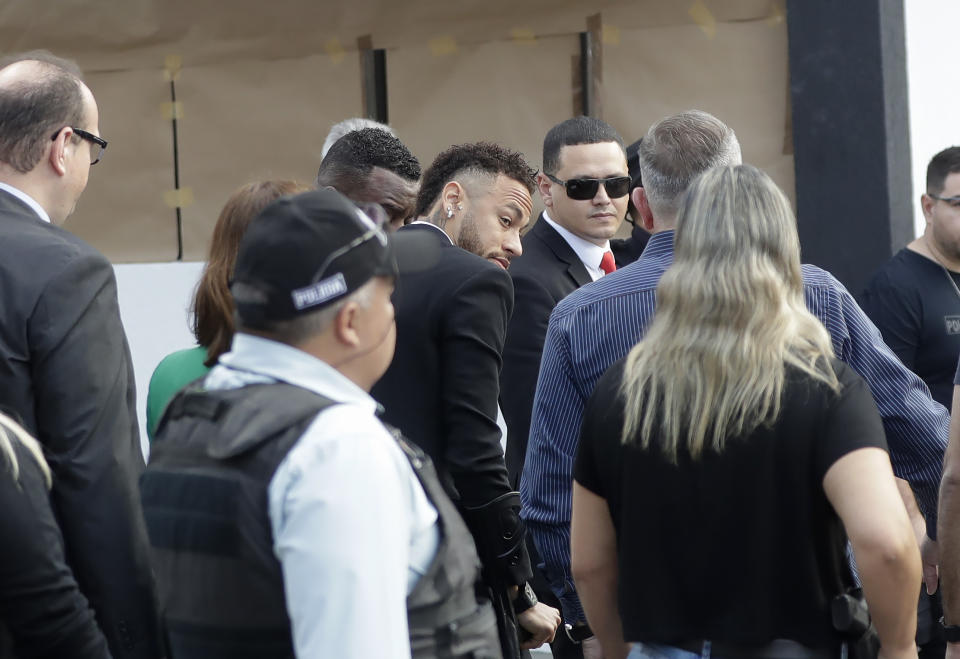 Brazilian soccer star Neymar, center, arrives to a police station to testify, after a woman accused him of rape, in Sao Paulo, Brazil, Thursday, June 13, 2019. Neymar denies any wrongdoing. (AP Photo/Andre Penner)