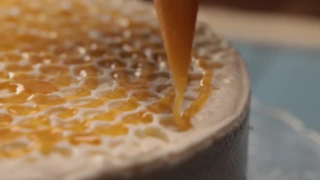 Drizzling honey over cheescake