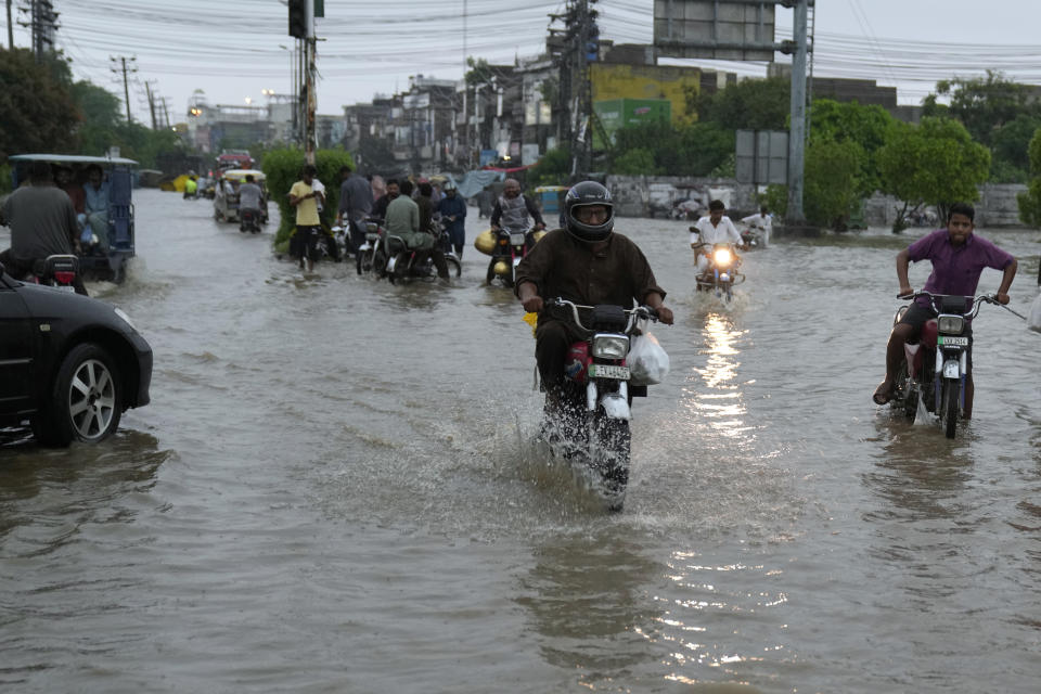Motorcyclists drive through a flooded road caused by heavy monsoon rainfall in Lahore, Pakistan, Wednesday, July 5, 2023. Officials say heavy monsoon rains have lashed across Pakistan, killing a number of people. (AP Photo/K.M. Chaudary)