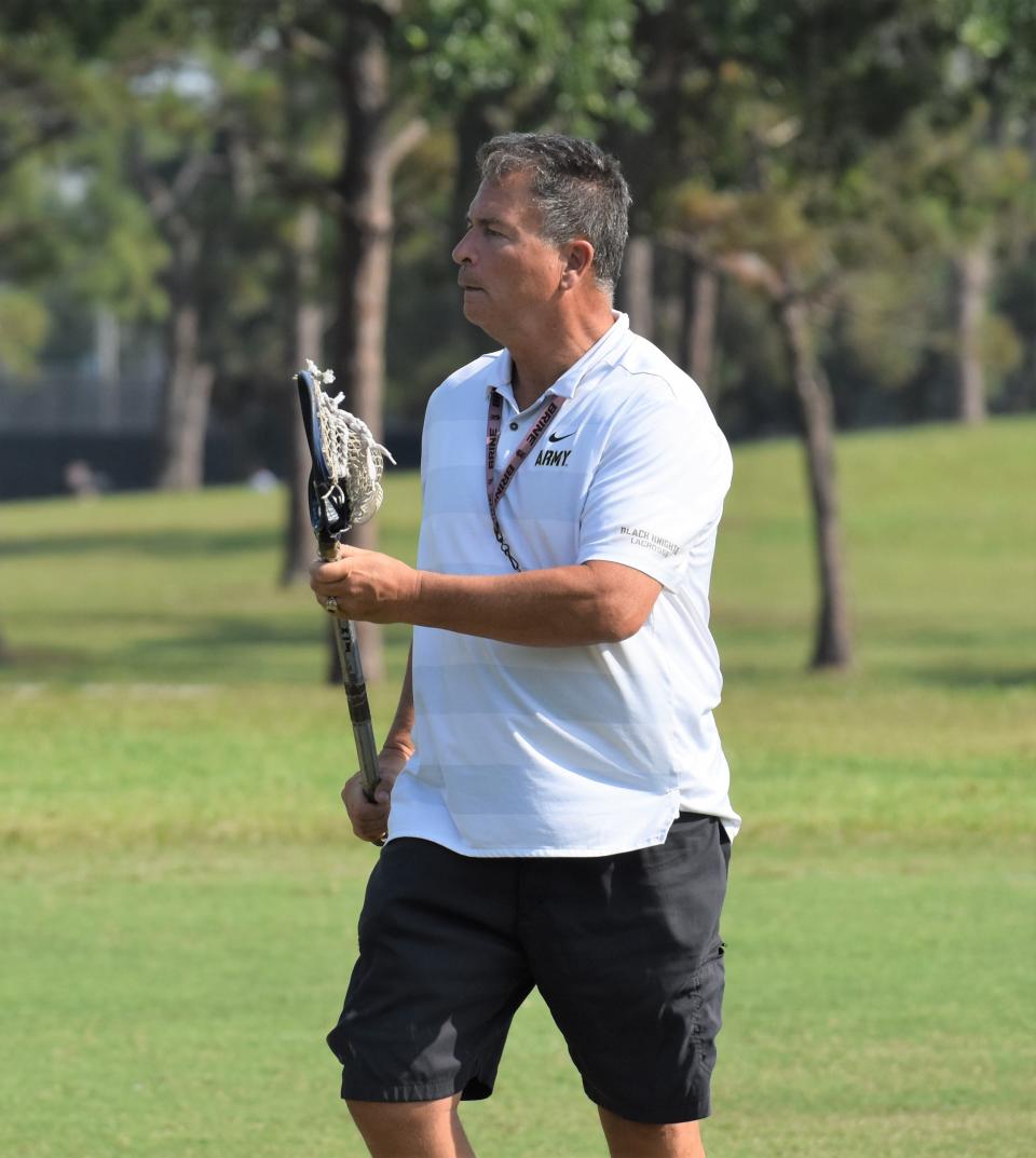 Palm Beach Central coach William Bauer conducts practice, picking up a stick and getting involved to help his players.