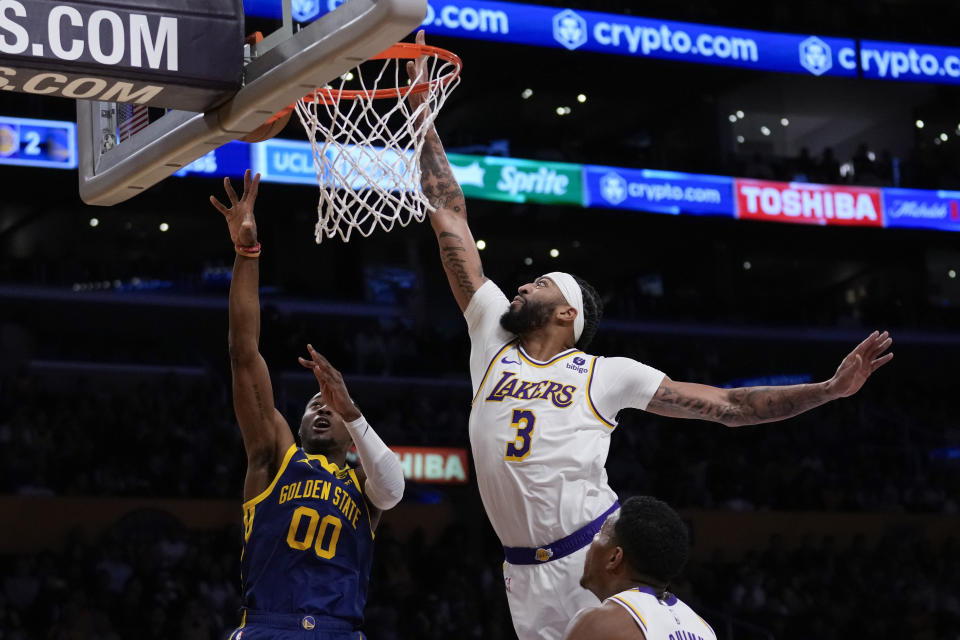 Golden State Warriors forward Jonathan Kuminga (00) shoots against Los Angeles Lakers forward Anthony Davis (3) during the first half of an NBA basketball game in Los Angeles, Saturday, March 16, 2024. (AP Photo/Ashley Landis)