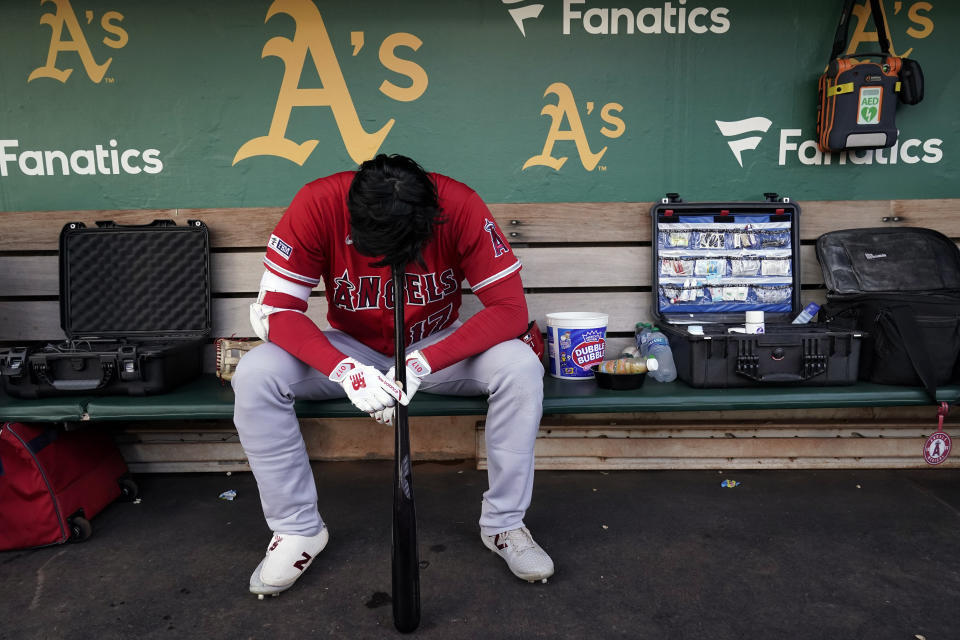 FILE - Los Angeles Angels' Shohei Ohtani sits in the dugout before the team's baseball game against the Oakland Athletics on Friday, Sept. 1, 2023, in Oakland, Calif. Ohtani will miss the rest of the season because of an oblique injury, the team announced, Saturday, Sept. 16, 2023. (AP Photo/Godofredo A. Vásque, File)