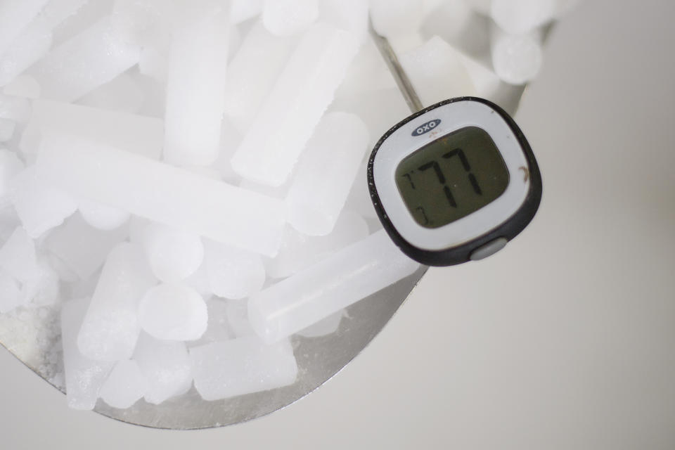 READING, ENGLAND - NOVEMBER 11: A thermometer displays a temperature of -77 degrees centigrade as it rests in a supply of coarse dry ice pellets at the Dry Ice Nationwide manufacturing facility on November 11, 2020 in Reading, England. Producing dry ice in a number of forms, the company provides both coarse pellets and slabs for use in temperature-controlled pharmaceutical logistics, pathological environments and chemical laboratories, as well as for food transportation. The covid-19 vaccine developed by Pfizer and BioNTech must be kept at ultra-cold temperatures in its journey from the production line to a patient's arm. To address this challenge, Pfizer developed a suitcase-sized box that uses dry ice to keep between 1,000 and 5,000 doses for 10 days at minus 70 degrees Celsius. (Photo by Leon Neal/Getty Images)