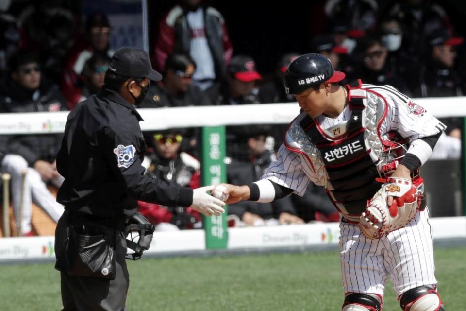韓國職棒捕手從主審手中拿球。（美聯社資料照）