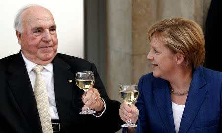 FILE PHOTO: Former German Chancellor Helmut Kohl (L) toasts with glasses of white wine with German Chancellor Angela Merkel after a ceremony of the Christian Democratic Union (CDU) party to mark the upcoming 20-year anniversary of the German unification in Berlin, Germany, October 1, 2010. REUTERS/Fabrizio Bensch/File Photo