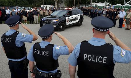 Police officers salute at a vigil for slain Fox Lake Police Lieutenant Charles Joseph Gliniewicz in Fox Lake, Illinois, United States, September 2, 2015. REUTERS/Jim Young